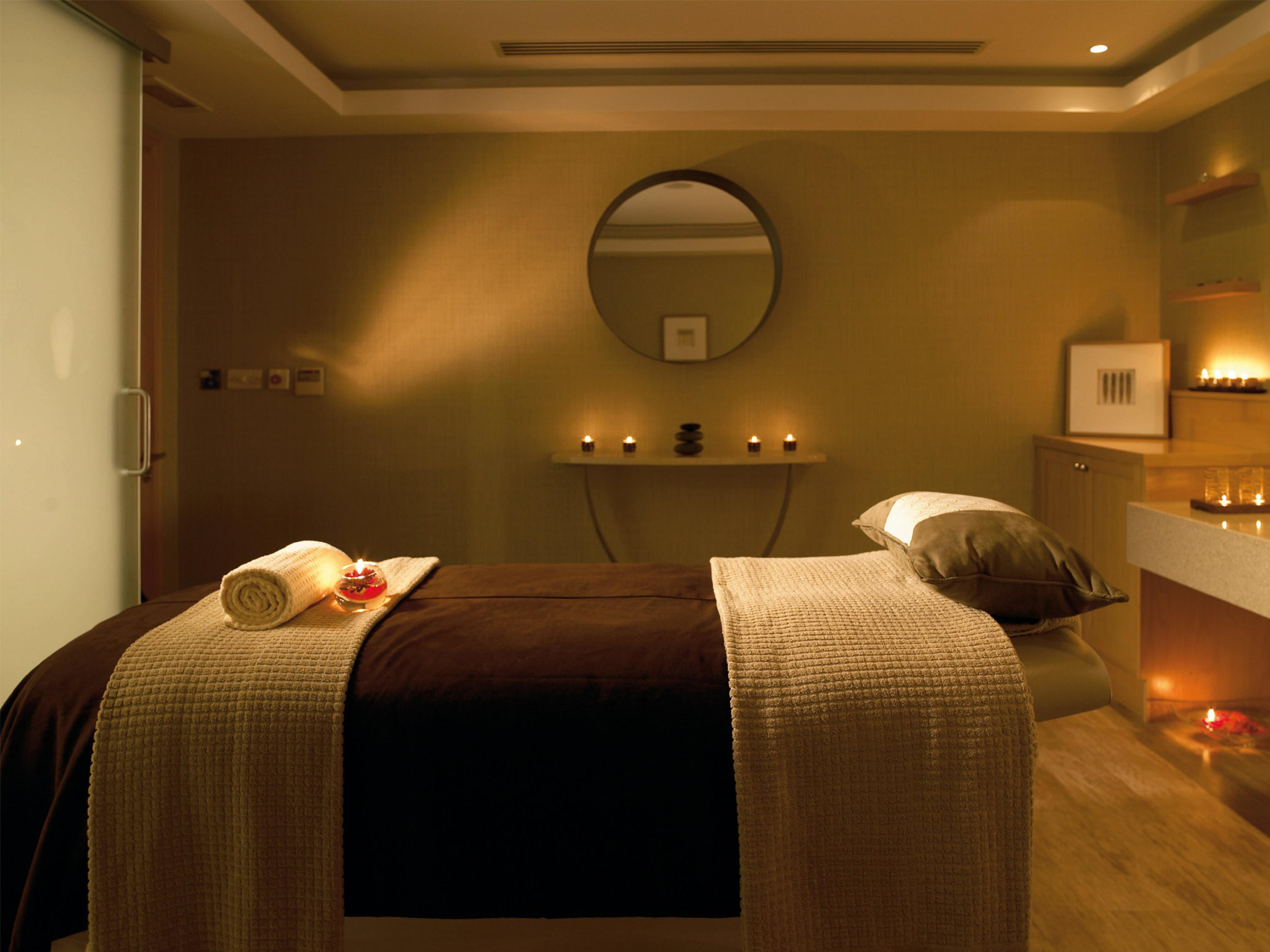 Macdonald Bath Spa Hotel Buitenkant foto The photo shows a serene spa room designed for relaxation and wellness. A comfortable massage table is centered in the room, covered with a soft, neutral-toned blanket. On the table, there is a rolled towel and a few decorative elements, possibly flo