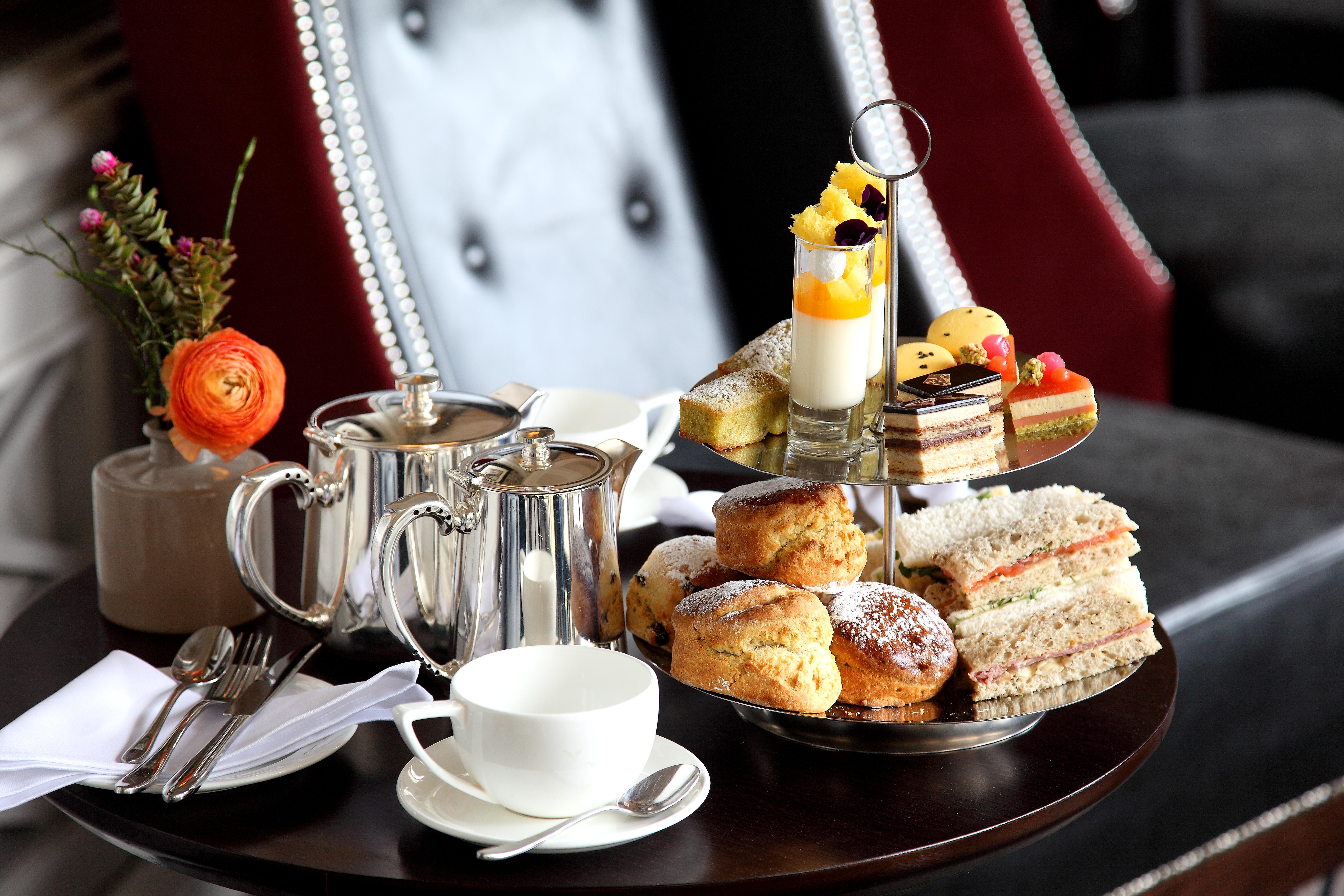 Macdonald Bath Spa Hotel Buitenkant foto The photo depicts an elegantly arranged afternoon tea setting. There is a tiered stand filled with a variety of treats, including scones, sandwiches, and small desserts like cakes and pastries. Accompanying this is a teapot and a cup on the table, su